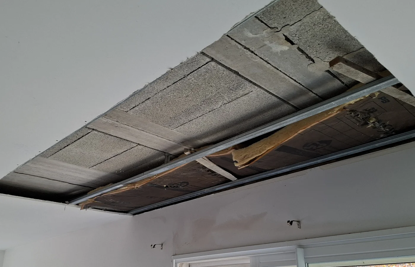 Plafond ouvert avant réparation dans un appartement à Lyon, structure et isolant visibles